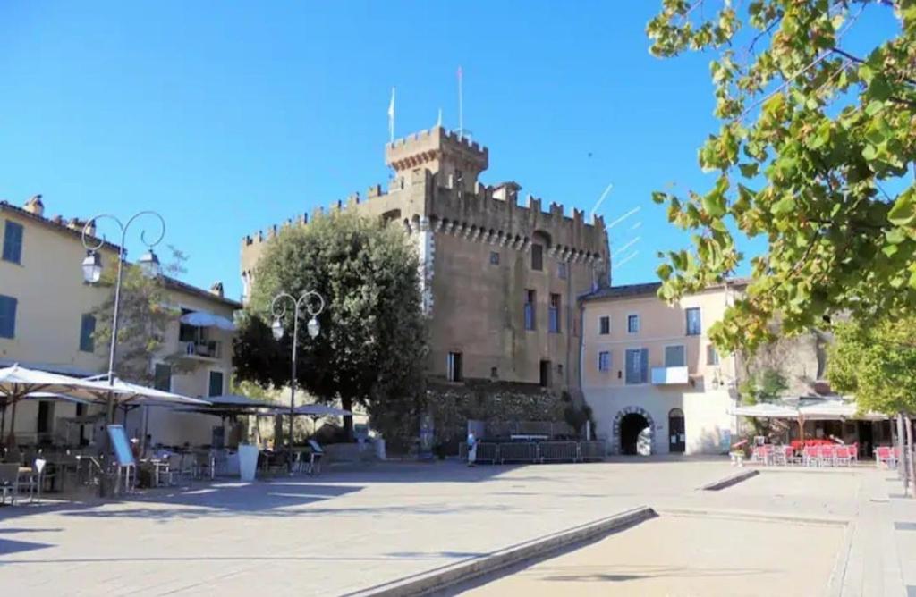 un grand bâtiment avec une tour au sommet dans l'établissement Charming studio Haut-de-Cagnes, à Cagnes-sur-Mer