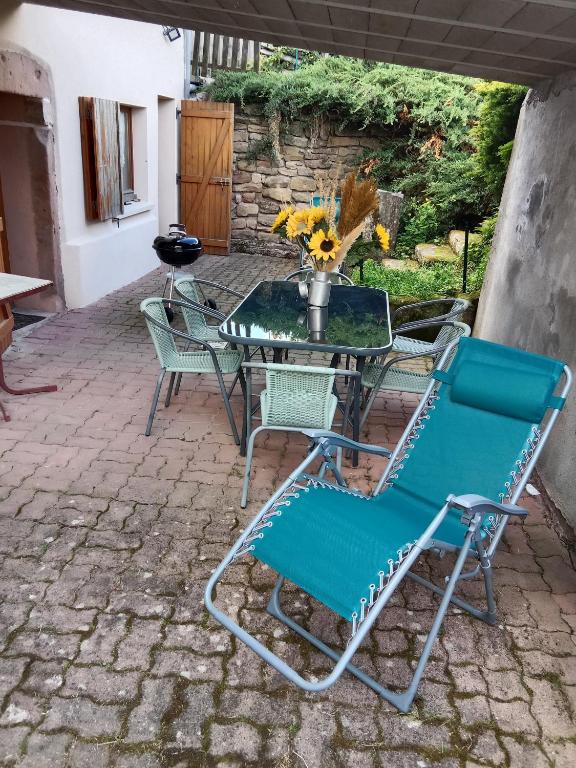 d'une terrasse avec une table et des chaises en verre. dans l'établissement GÎTE LE GELEINFÊTE II VOSGES à proximité de GERARDMER, à Herpelmont