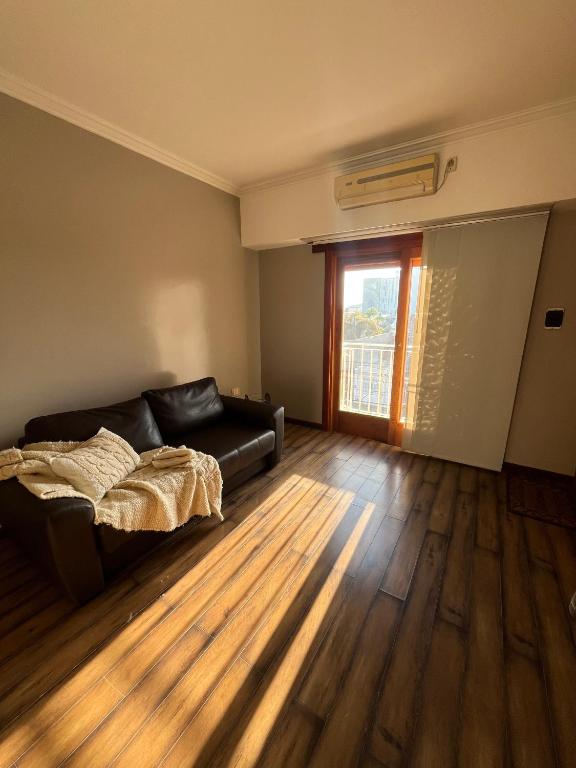 a living room with a couch and a window at El Anexo MV in Olavarría