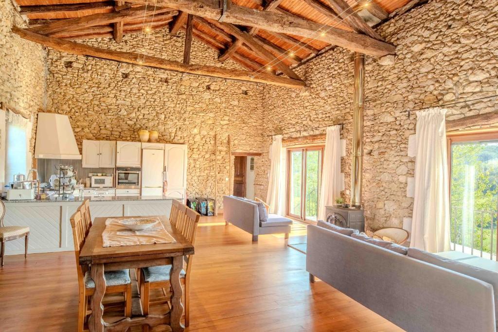 a large living room with a table and a stone wall at La Bastide in Puycalvel Lautrec