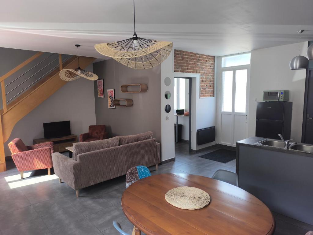un salon avec une table et un canapé dans l'établissement Maison proche Baie de Somme mer campagne, à Tully