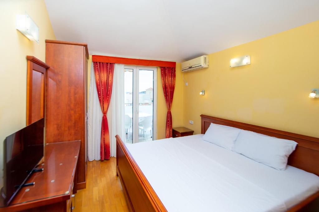 a bedroom with a large bed and a window at Apartmani Becici in Bečići