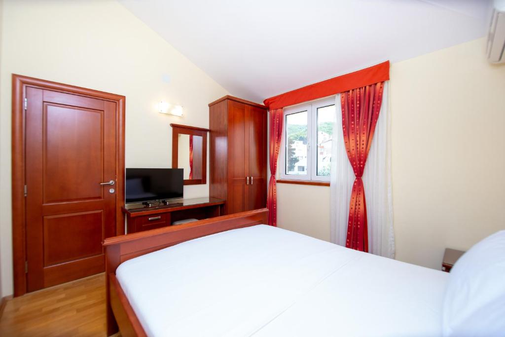 a bedroom with a bed and a window at Apartmani Becici in Bečići
