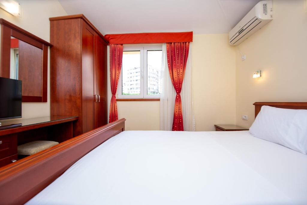 a bedroom with a bed and a window at Apartmani Becici in Bečići