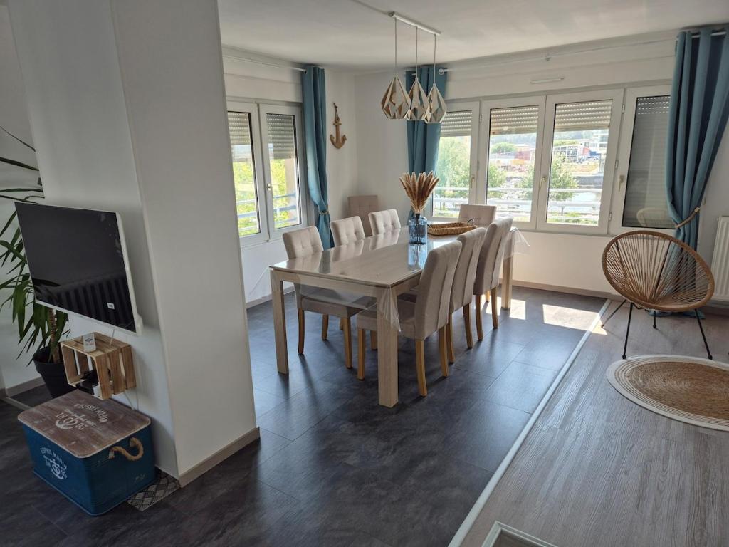 une salle à manger et un salon avec une table et des chaises dans l'établissement Grand appartement L'Hélice - Vue port- 4 Chambres, à Boulogne-sur-Mer