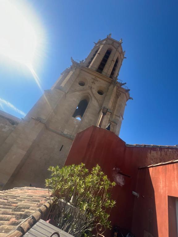 une tour d'un bâtiment avec une horloge dans l'établissement françoise CAUWEL, à Aix-en-Provence