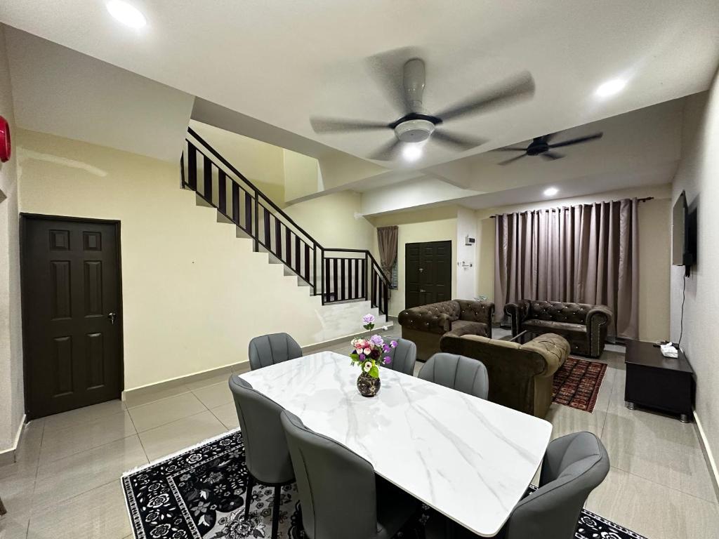 a living room with a white table and chairs at Homestay Ummi Gong Badak 2 in Kuala Terengganu