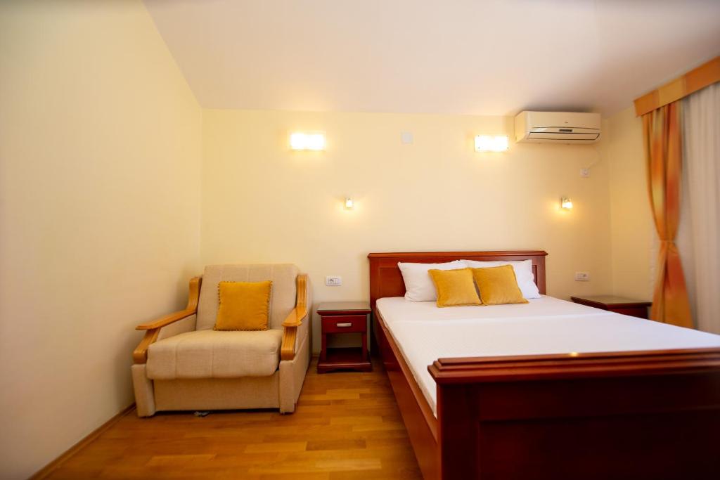 a bedroom with a bed and a chair at Apartmani Becici in Bečići