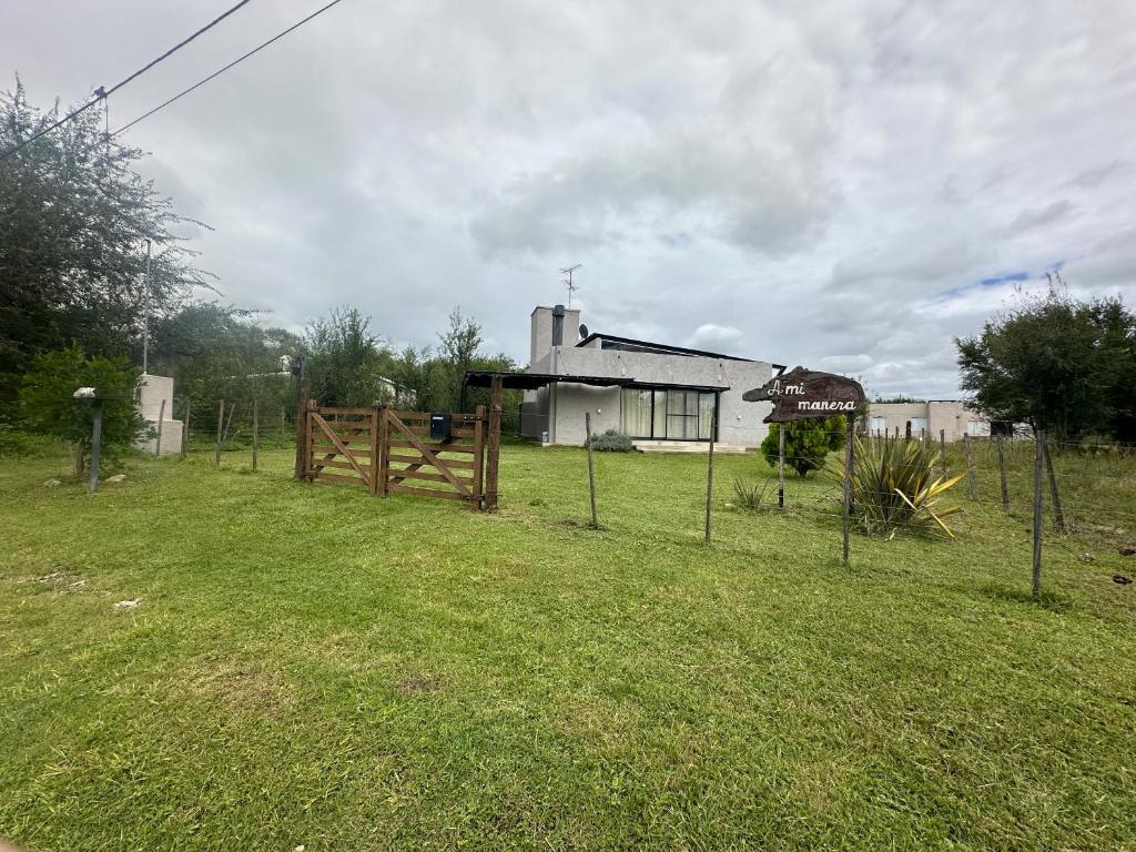 a fence in front of a house with a yard at HERMOSA CASA 2 DORMITORIOS EN POTRERO DE GARAY in Potrero de Garay
