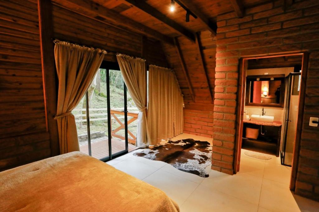 a bedroom with a bed and a window and a sink at Pousada Encanto Verde in Bom Jardim da Serra