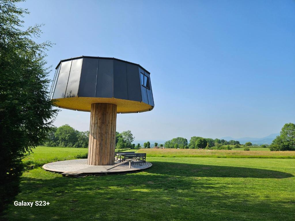a building on a pole with a bench in a field at LOGIS LAS CROZAS Le Mousseron orientable in Vernines