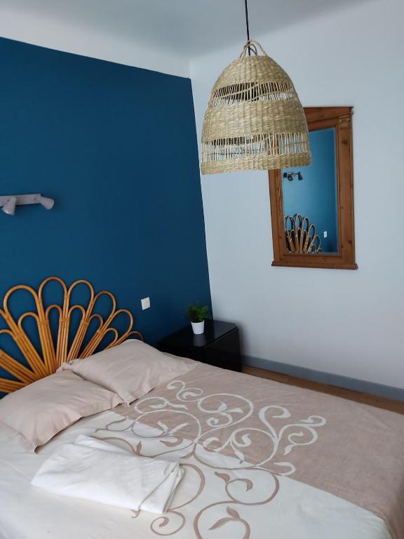 - une chambre dotée d'un lit avec un mur bleu et un miroir dans l'établissement Vigie, à Soorts-Hossegor