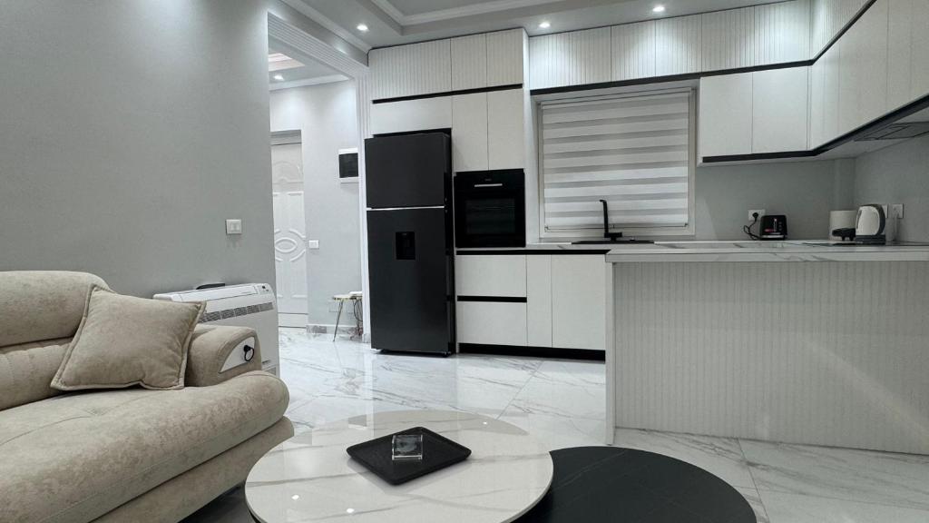 a living room with a couch and a kitchen at Ada Apartment Hilltop Serenity in Durrës