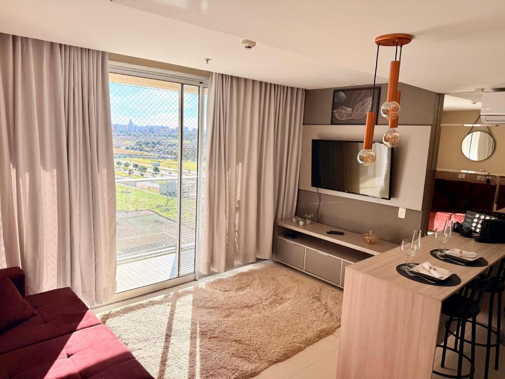 un salon avec une table et une grande fenêtre dans l'établissement Apto aconchegante no DF Plaza, à Brasilia