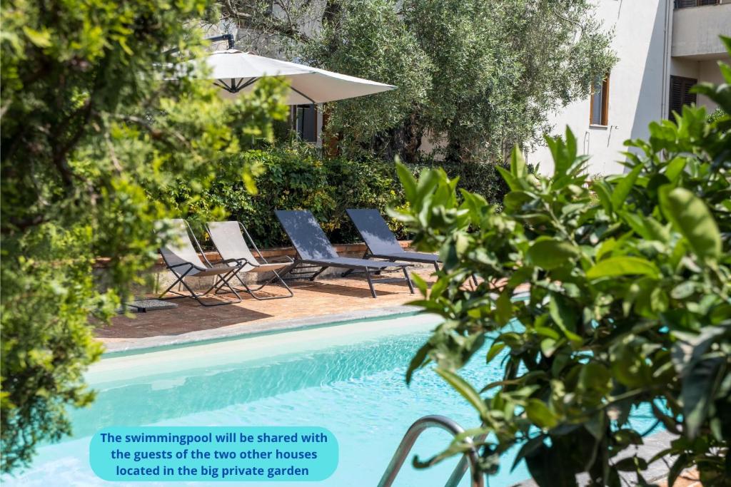 una piscina con tumbonas y árboles en Villa Costanza, en Mondello