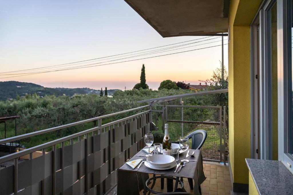 a table with wine glasses on a balcony with a view at Borea Strunjan in Portorož