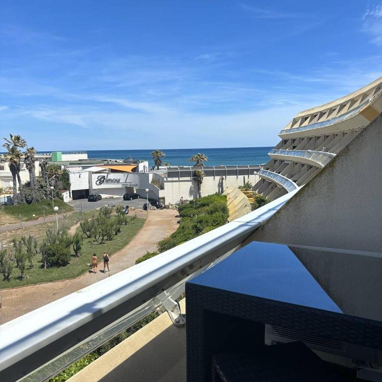 une vue sur l'océan depuis le balcon d'un immeuble dans l'établissement Studio BROWN Héliopolis D 29 - Luxe - 2 personnes, au Cap d'Agde