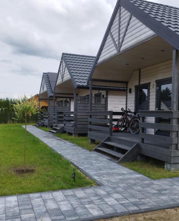 a row of houses with bikes parked on the porch at Domki Pod Świerkami in Jezierzany
