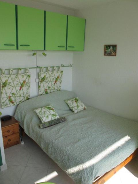- une petite chambre avec un lit doté d'armoires vertes dans l'établissement Studio Héliopolis E20 - 2 personnes, au Cap d'Agde