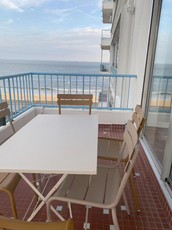 une table et des chaises sur un balcon avec vue sur l'océan dans l'établissement Appartement Vue mer La Baule, à La Baule
