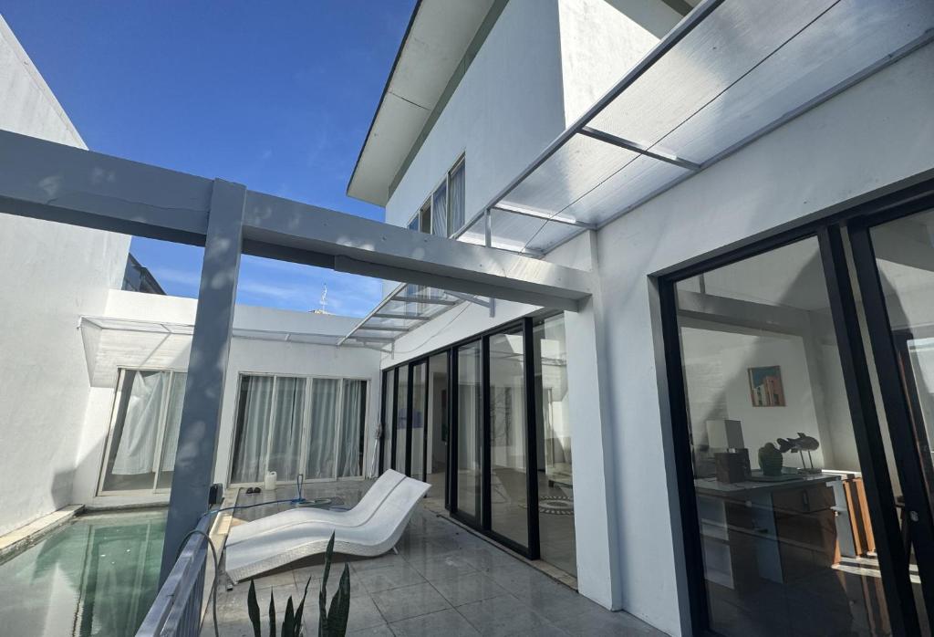 努沙杜瓦3 BR Chrysanthemum Villa nusadua的一座带游泳池和玻璃窗的房子