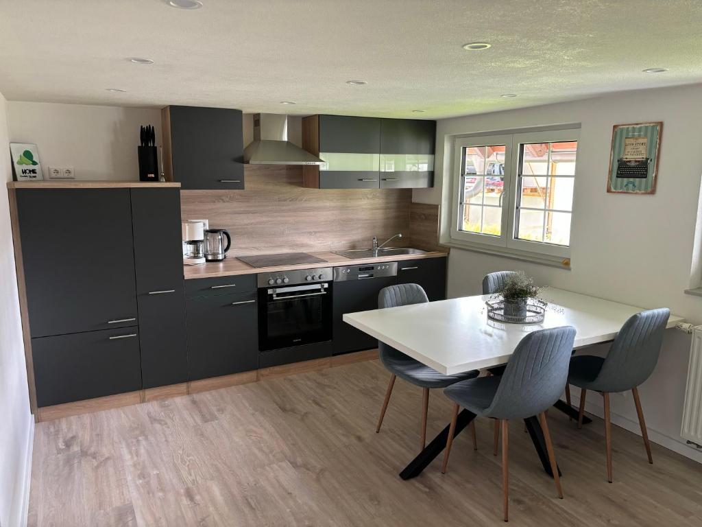 a kitchen with a white table and chairs and a stove at FeWo-Viktoria in Rheinau