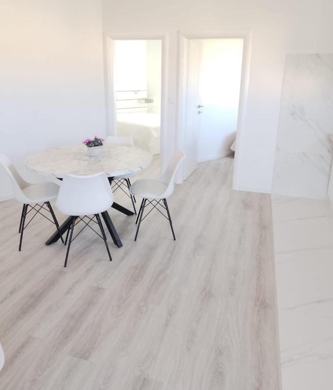 a dining room with a table and white chairs at Monami- Apartman Mia in Vodice