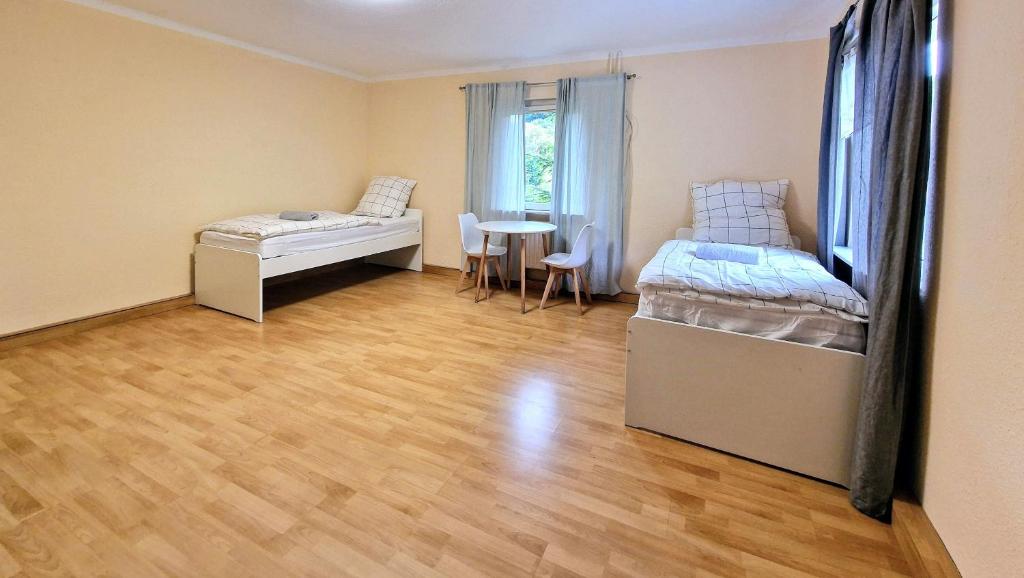 KürtenにあるVS- Kürten Comfort Apartmentのベッド2台とテーブルがある部屋