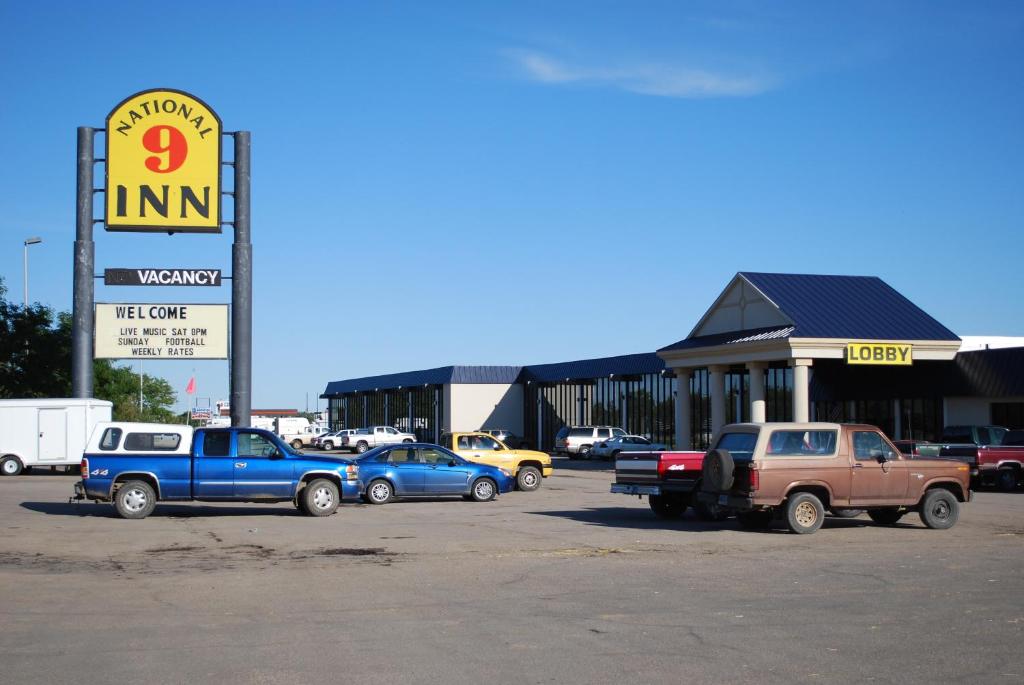 un grupo de autos estacionados frente a una tienda en National 9 Inn Gillette, en Gillette