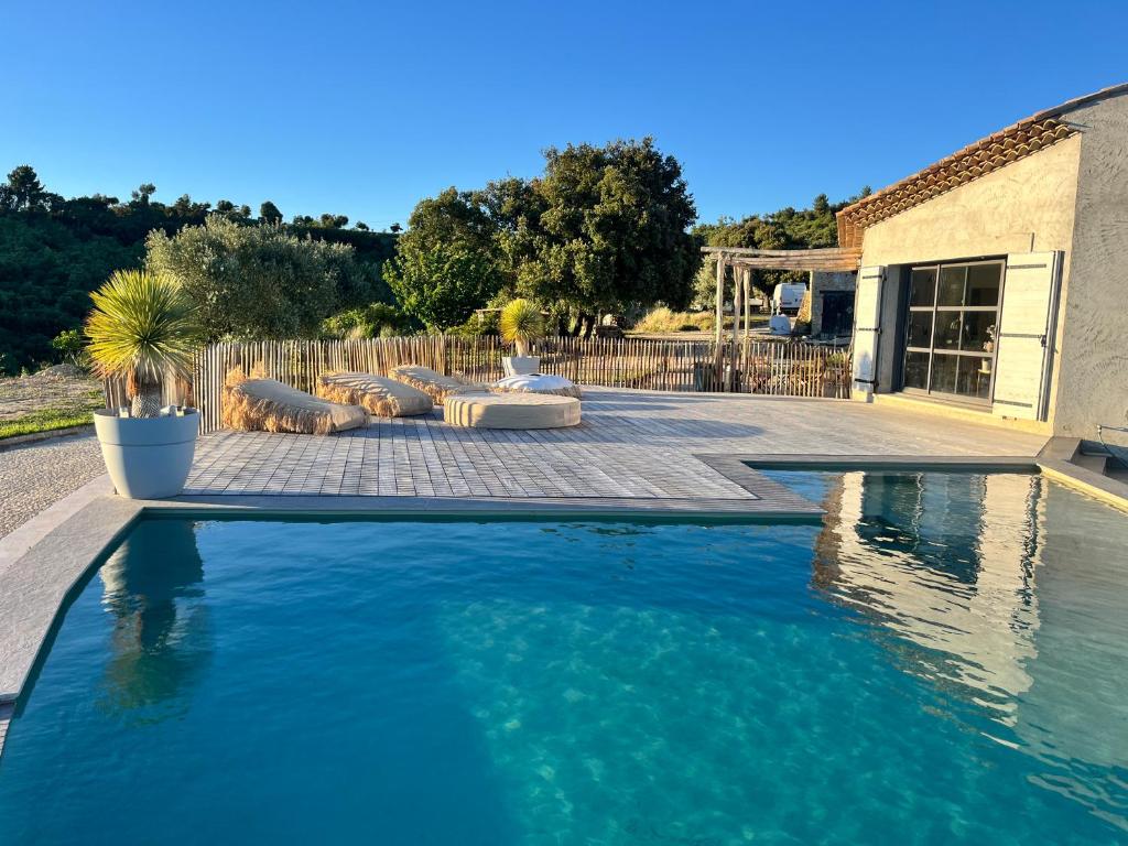 une piscine dans une cour à côté d'une maison dans l'établissement La colle aux sources, à Esparron-de-Verdon