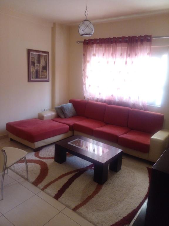 a living room with a red couch and a coffee table at Ofellows - Kristal Center in Tirana