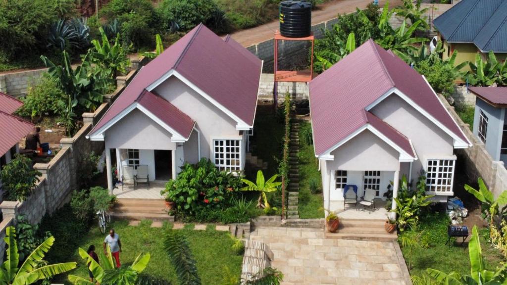 een klein wit huis met een paars dak bij Rejoice Evermore Homes in Arusha