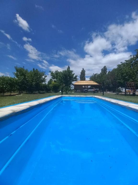 a large blue swimming pool with a building in the background at Finca Don Juan Piedra Alta in Junín