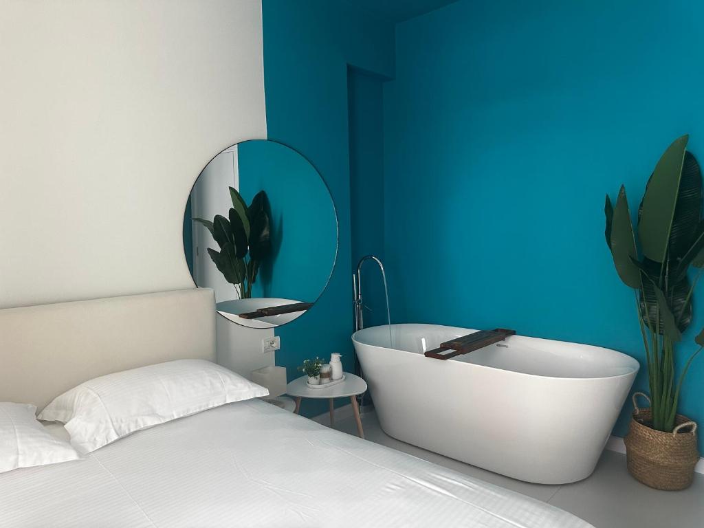 a bedroom with a white bed and a bath tub at LARIMAR Lungomare Vlore in Vlorë