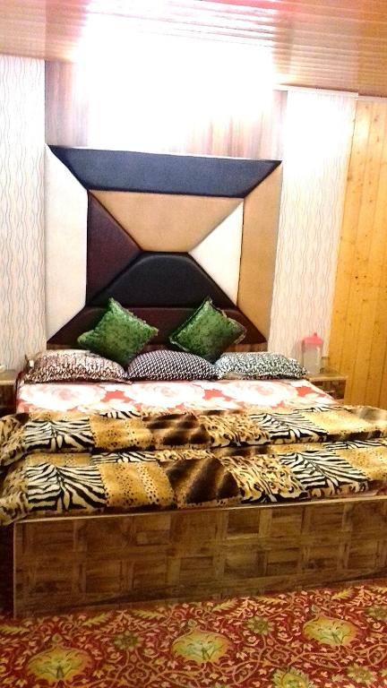 a large bed with a black headboard in a room at HOTEl momin in Srinagar