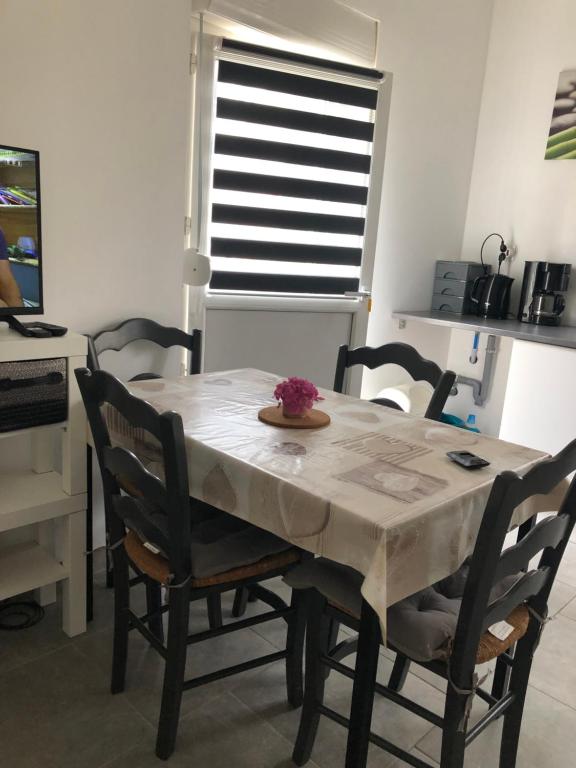 d'une table à manger, de chaises, d'une table et d'une fenêtre. dans l'établissement Le Grain de Sable, à Berck-sur-Mer