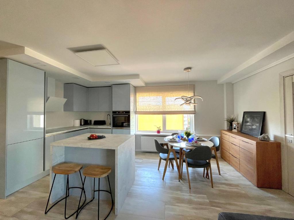 a kitchen and dining room with a table and chairs at Family Nest in Ventspils