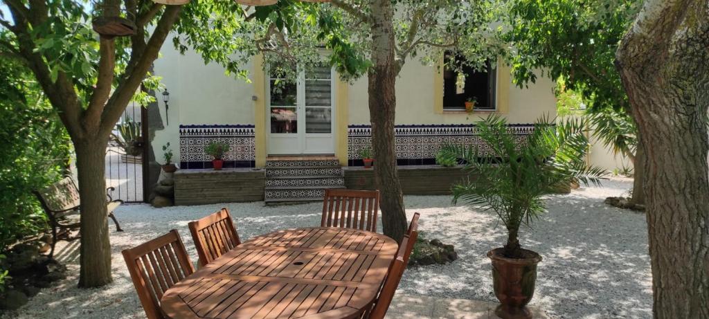 une table et des chaises en bois devant une maison dans l'établissement Un joli jardin méditerranéen, au Cap d'Agde