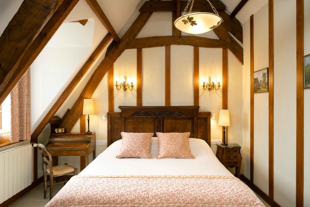 Postel nebo postele na pokoji v ubytování Hôtel Le Manoir De Mathan Crépon à la campagne 5 mn d'Arromanches et 10 mn de Bayeux