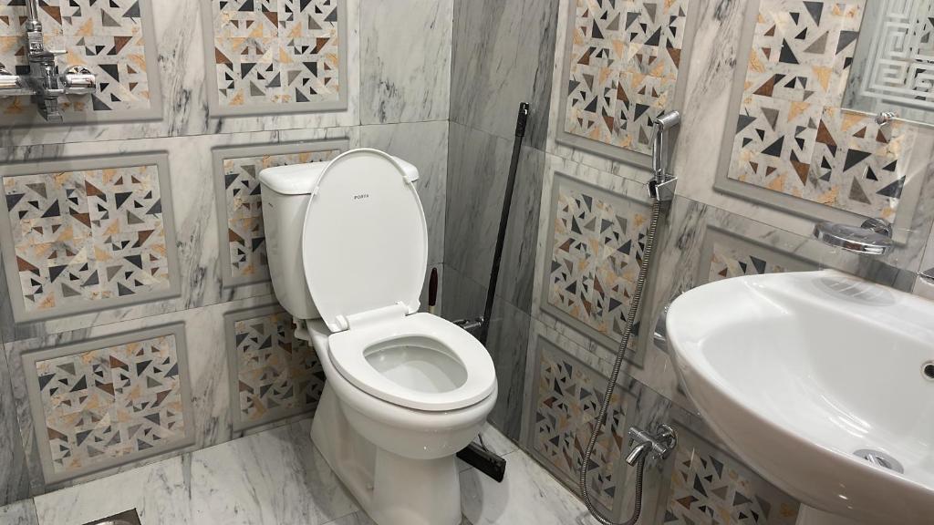 a bathroom with a toilet and a sink at Midways Guest House and Hotels in Islamabad