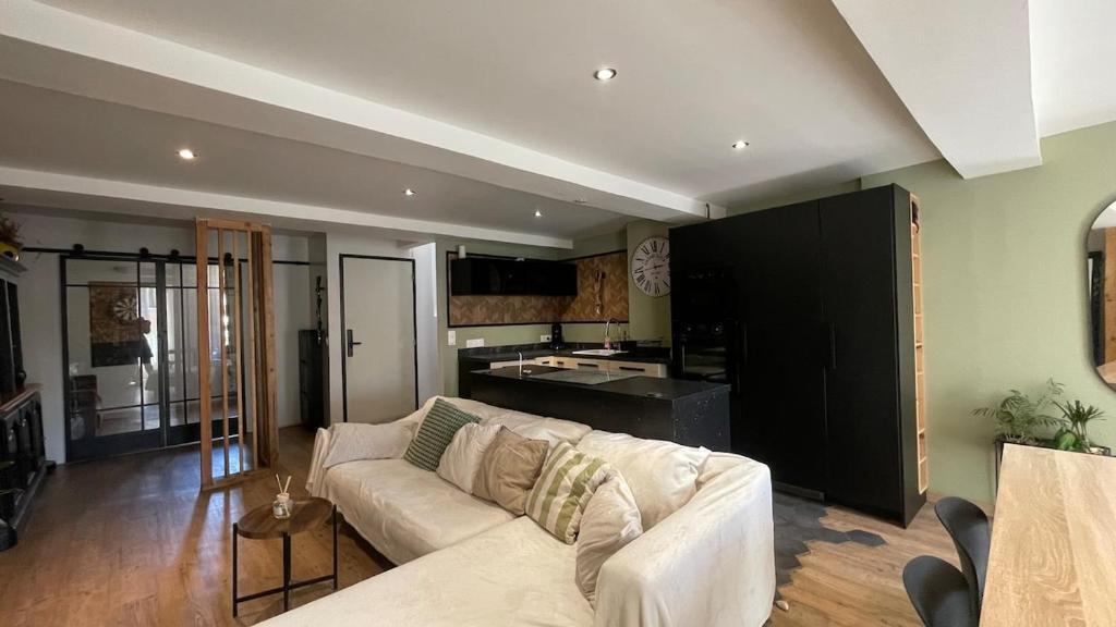un salon avec un canapé blanc et une cuisine dans l'établissement Appartement Duplex Carnoules, à Carnoules