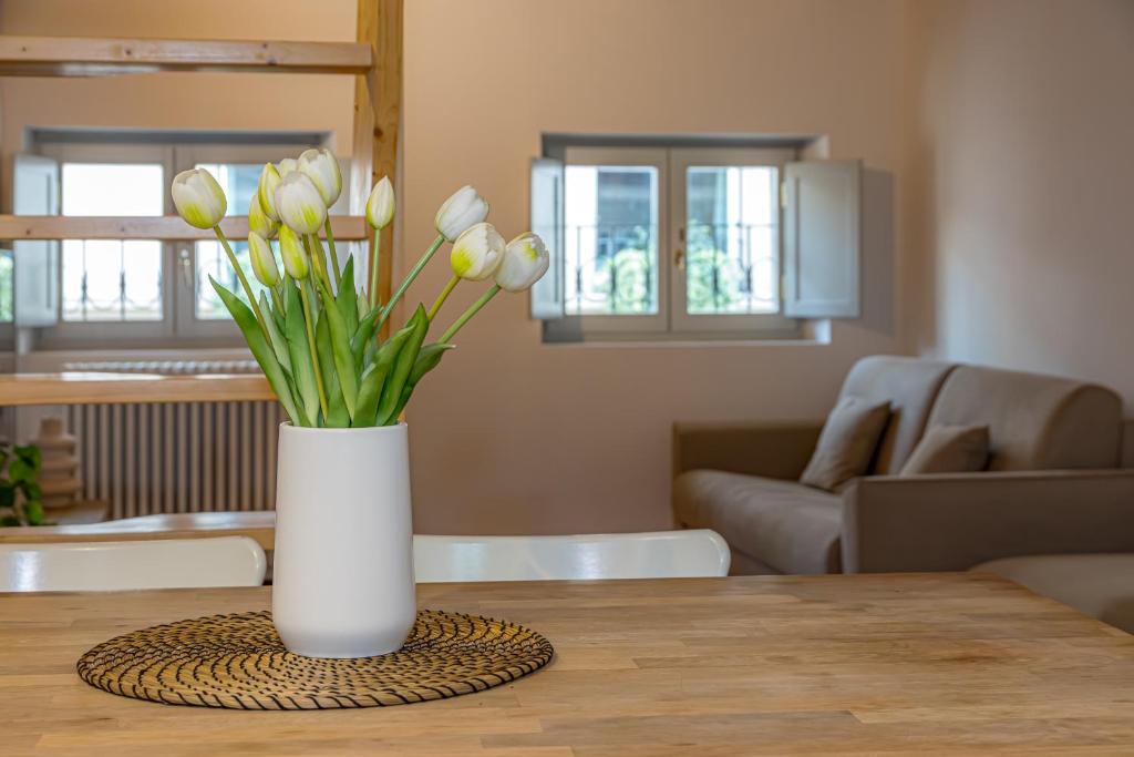 a vase of white tulips sitting on a table at Atena at Como Duomo in Como