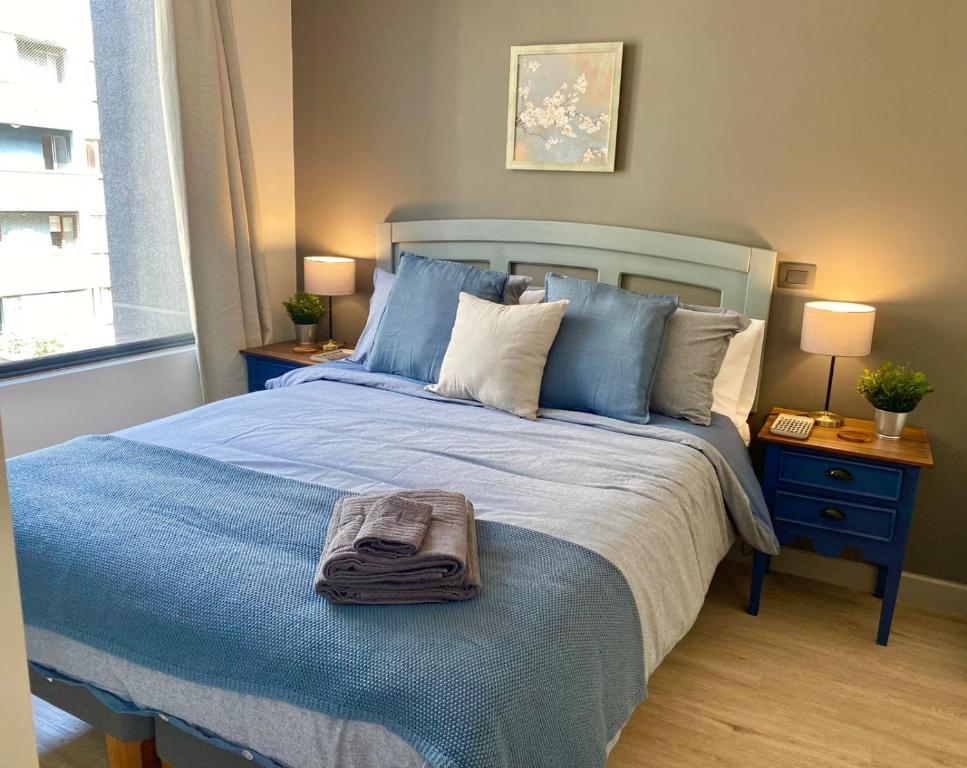 a bedroom with a blue bed with a towel on it at Deptos Boutique en pleno centro de Santiago in Santiago