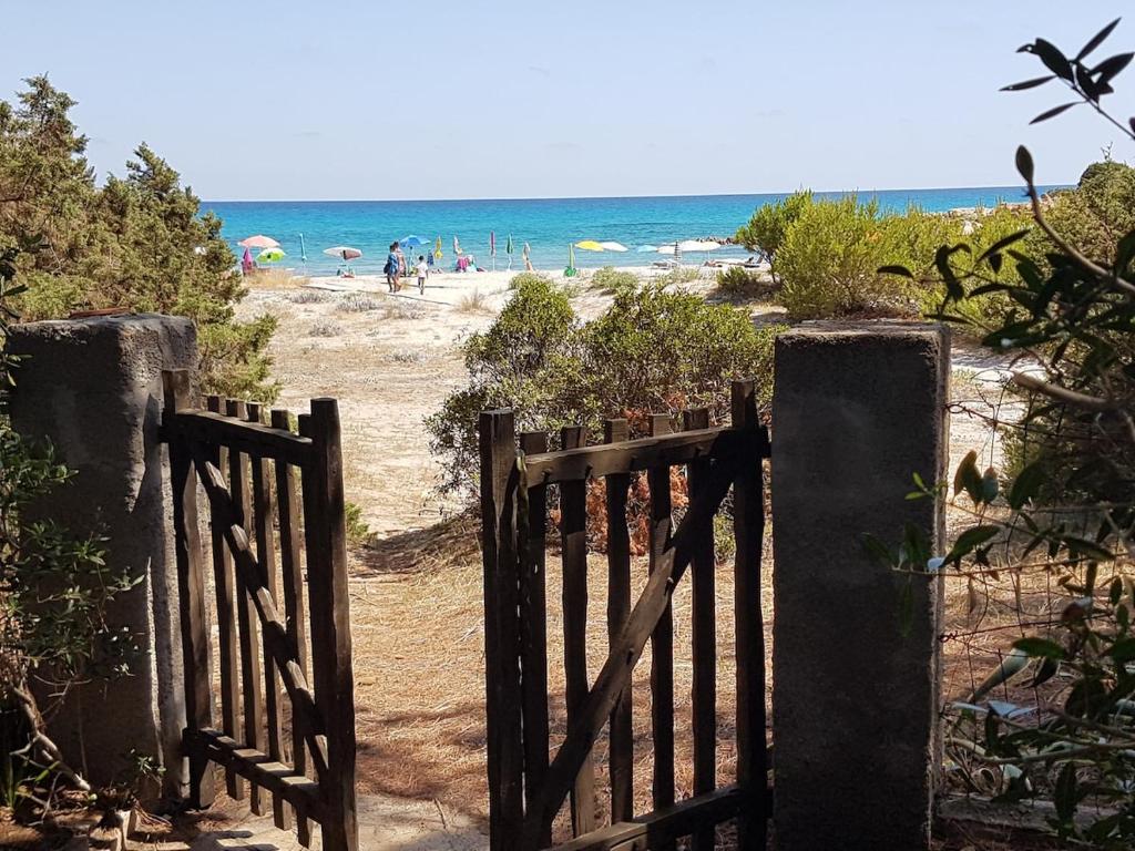 カーラ・リベロットにあるBeachfront villa, right ON SAND!のビーチに人々がいる、ビーチへの開いた門