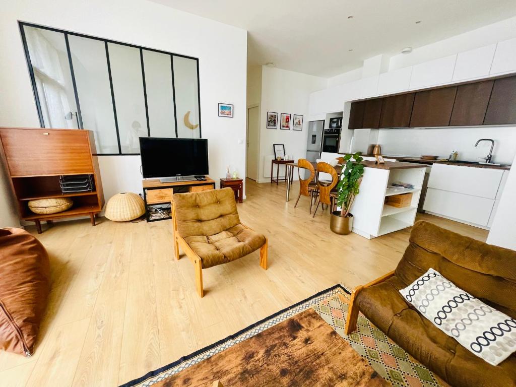 un salon avec un canapé et des chaises et une cuisine dans l'établissement Liberté - Grand appartement 4 pers avec parking Lille Centre, à Lille