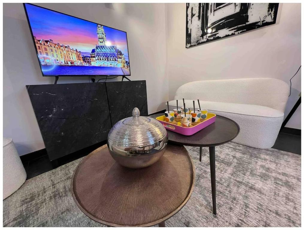 un salon avec une table et une télévision dans l'établissement Maison Hyper Centre d'Arras - 3 chambres parentales, à Arras