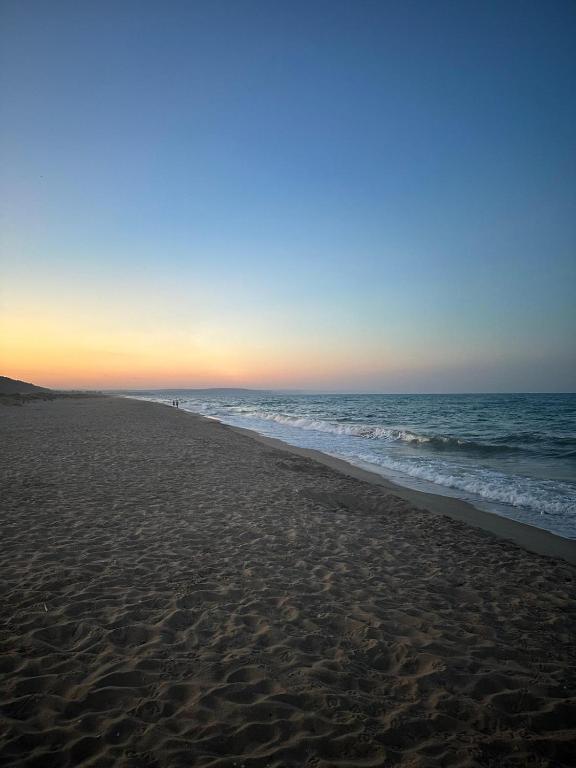 a beach at sunset with the ocean in the background at 2 Zimmerwohnung in Shkorpilovtsi