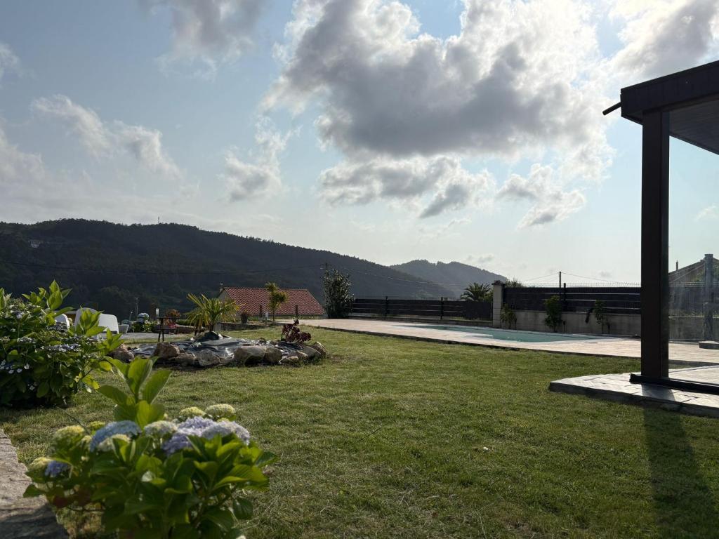 a grassy yard with a view of a mountain at Ceranzos 61B Pool Beach House in Jove