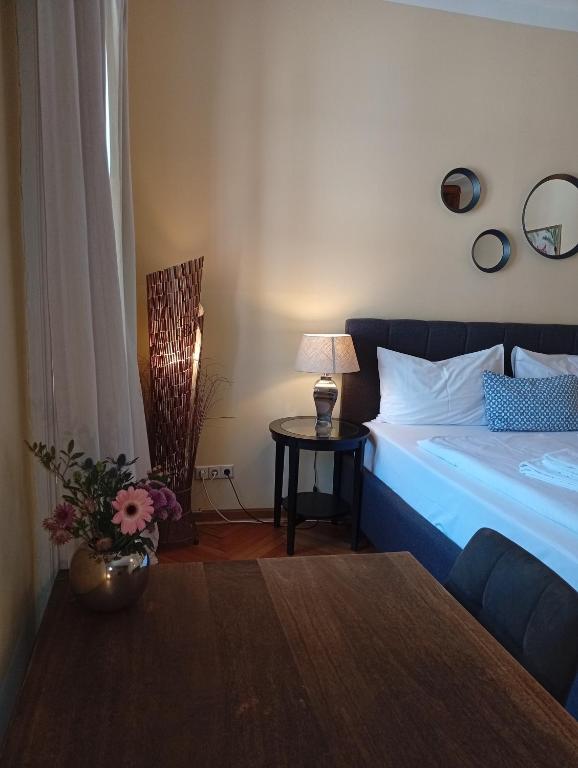 a bedroom with a bed and a table with a lamp at arte vida boutique guesthouse in Salzburg