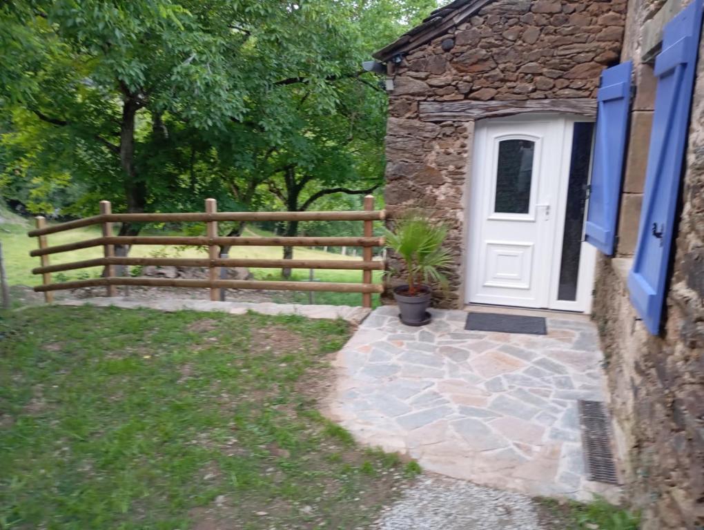 une maison avec une porte en bois et une porte blanche dans l'établissement Le sécadou, à Montirat